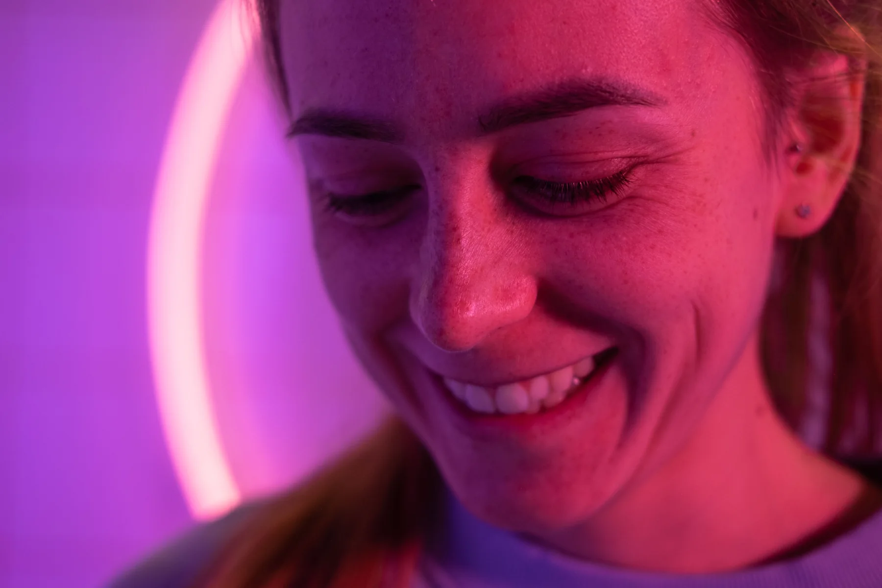 Lächelnde Person in violettem Licht